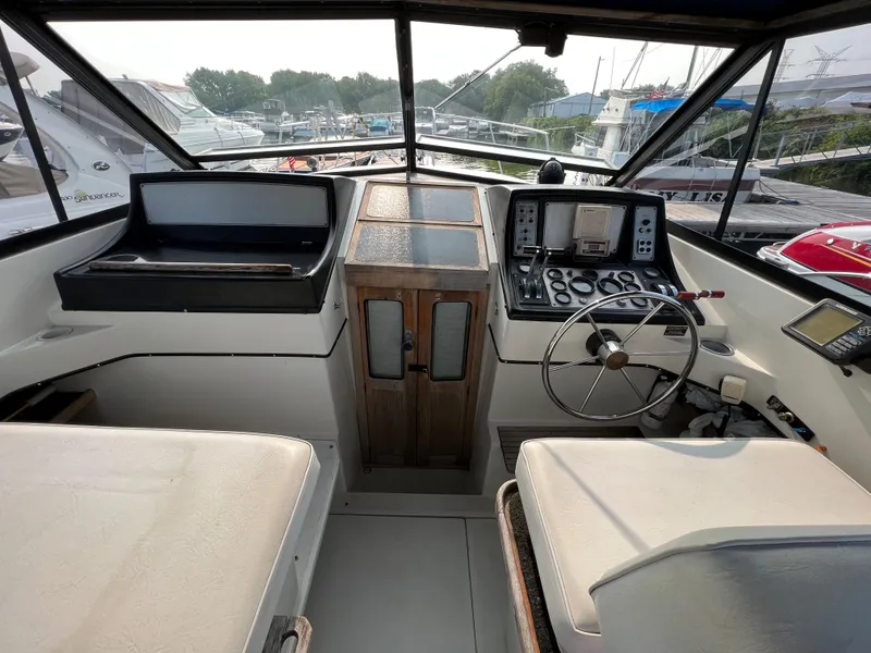 Slide: The Image of Interior view of 1987 Carver Riviera 2807 boat cockpit with steering wheel and control panel. - 7