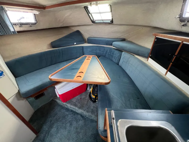 Slide: The Image of Interior of 1987 Carver Riviera 2807 boat with blue seating and wooden table. - 9