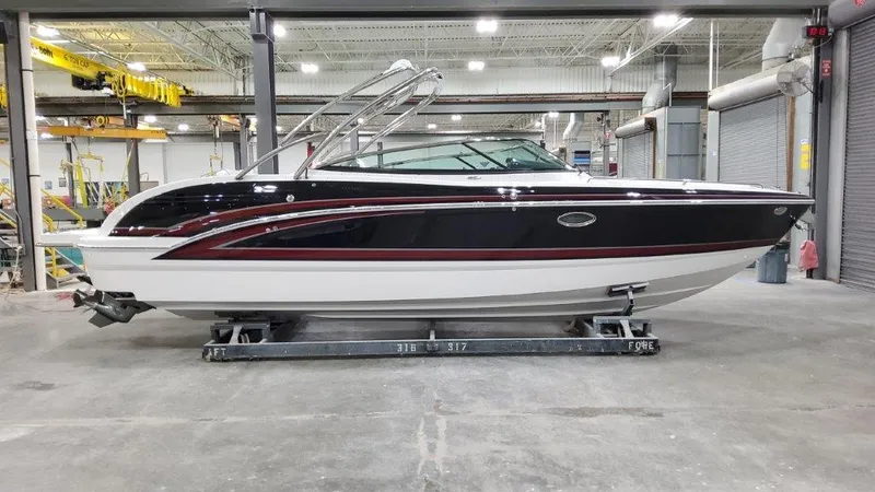 Slide: The Image of 2025 Formula 290 Bowrider boat in a warehouse setting, side view. - 0