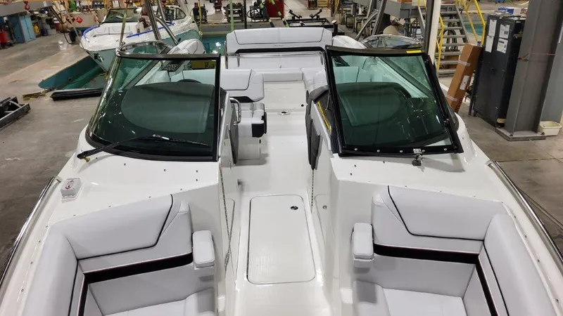 Slide: The Image of 2025 Formula 290 Bowrider with sleek white seating and modern design in a showroom. - 11
