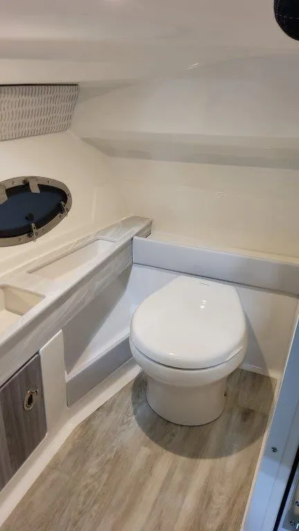 Slide: The Image of 2025 Formula 290 Bowrider boat interior bathroom with modern fixtures and wood flooring. - 13