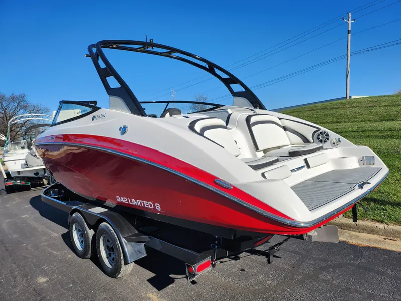 Slide: The Image of 2016 Yamaha Boats 242 Limited S on trailer, red and white design, parked outdoors. - 3