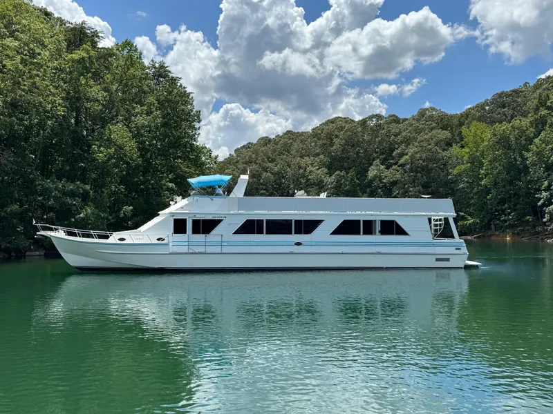 The Image of 1997 Lazy Days River Cruiser on a serene lake with lush green trees. - 0