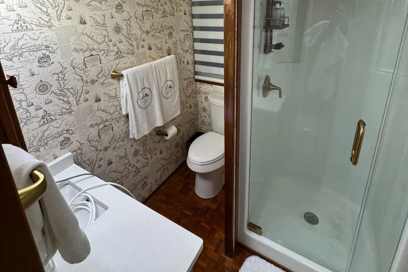 Slide: The Image of Bathroom interior of 1997 Lazy Days River Cruiser with shower and patterned wallpaper. - 13