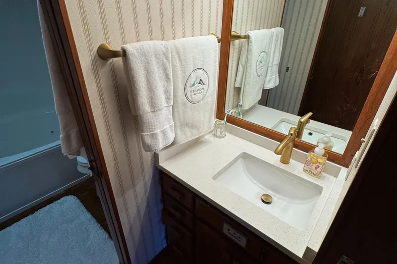 Slide: The Image of Bathroom vanity on 1997 Lazy Days River Cruiser with gold faucet and mirror. - 14