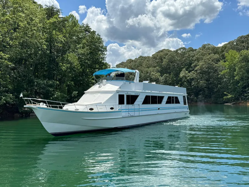 Slide: The Image of 1997 Lazy Days River Cruiser on a serene lake, surrounded by lush greenery and blue skies. - 2