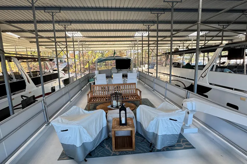 Slide: The Image of 1997 Lazy Days River Cruiser with covered deck and seating area in marina. - 21