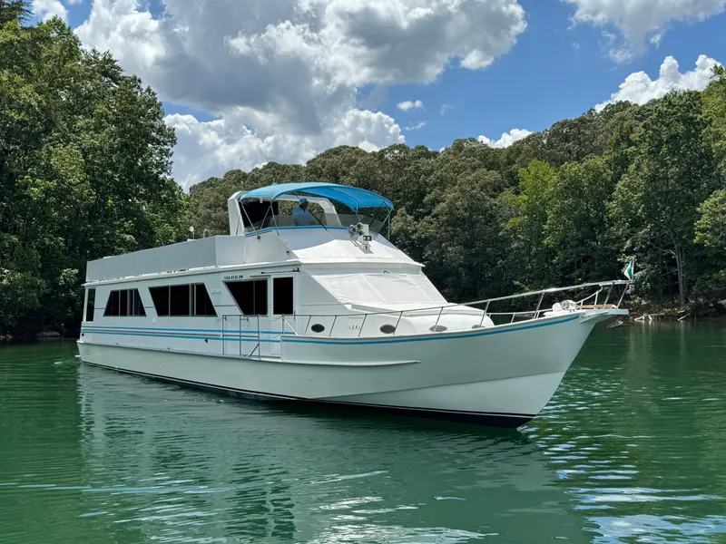 Slide: The Image of 1997 Lazy Days River Cruiser on a serene lake with lush green trees. - 5