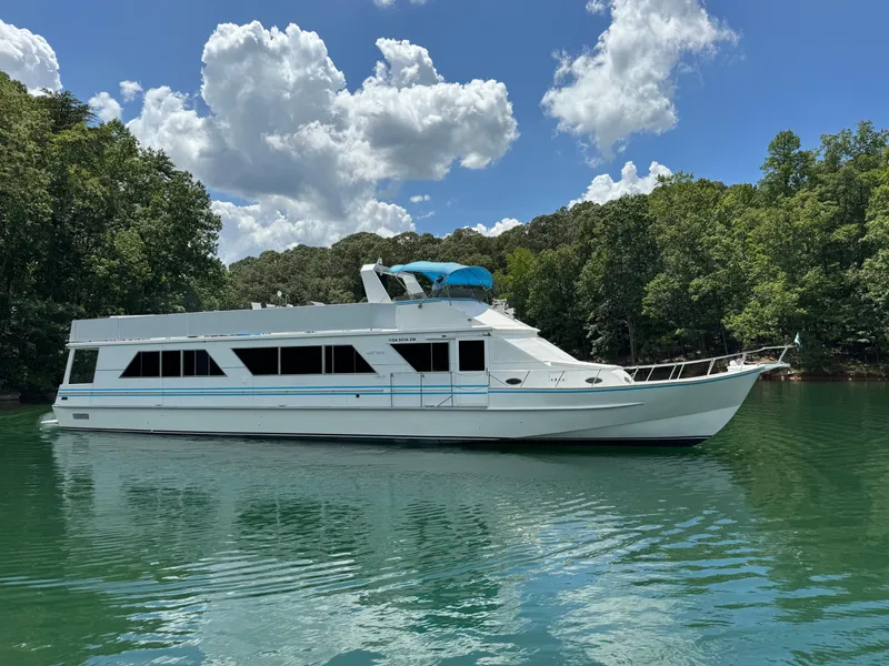 Slide: The Image of 1997 Lazy Days River Cruiser on a serene lake with lush green surroundings. - 6