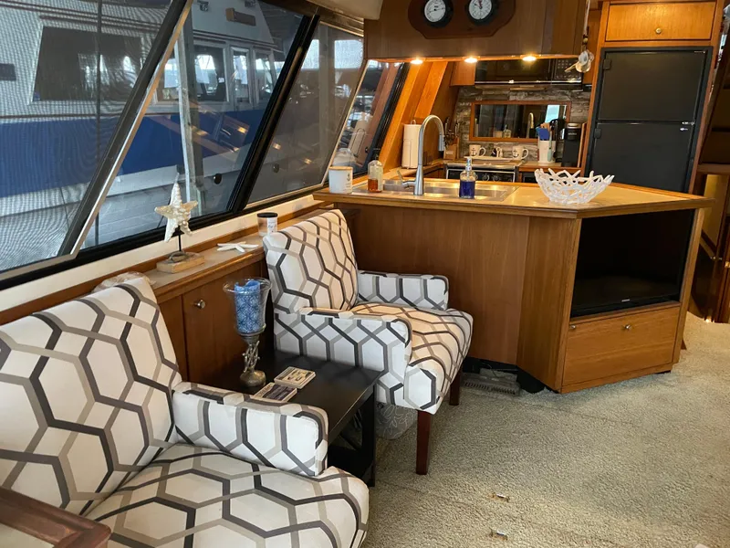 Slide: The Image of Interior of 1995 Bayliner 4788 Pilot House Motoryacht with patterned chairs and wooden cabinetry. - 18