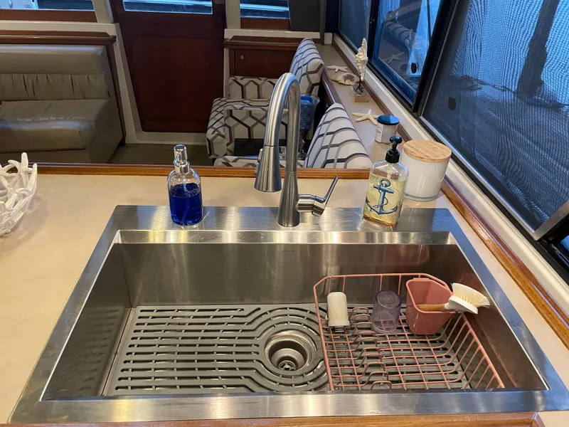 Slide: The Image of Modern kitchen sink on 1995 Bayliner 4788 Pilot House Motoryacht with soap dispensers and drying rack. - 27
