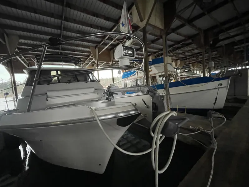 Slide: The Image of 1995 Bayliner 4788 Pilot House Motoryacht docked in a covered marina. - 6