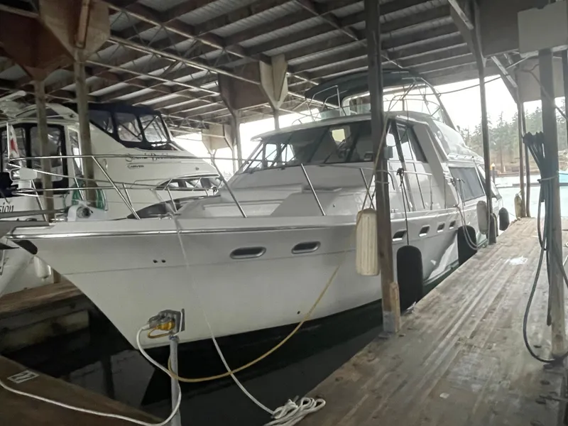 Slide: The Image of 1995 Bayliner 4788 Pilot House Motoryacht docked in a covered marina. - 7