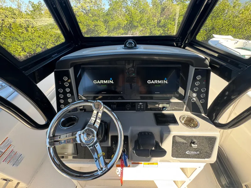 Slide: The Image of 2023 Robalo R270 Center Console helm with Garmin displays and steering wheel. - 25