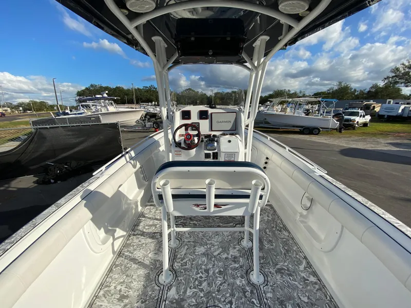 Slide: The Image of 2020 Glasstream 280 Pro-XS boat interior with steering console and seating, parked outdoors. - 12