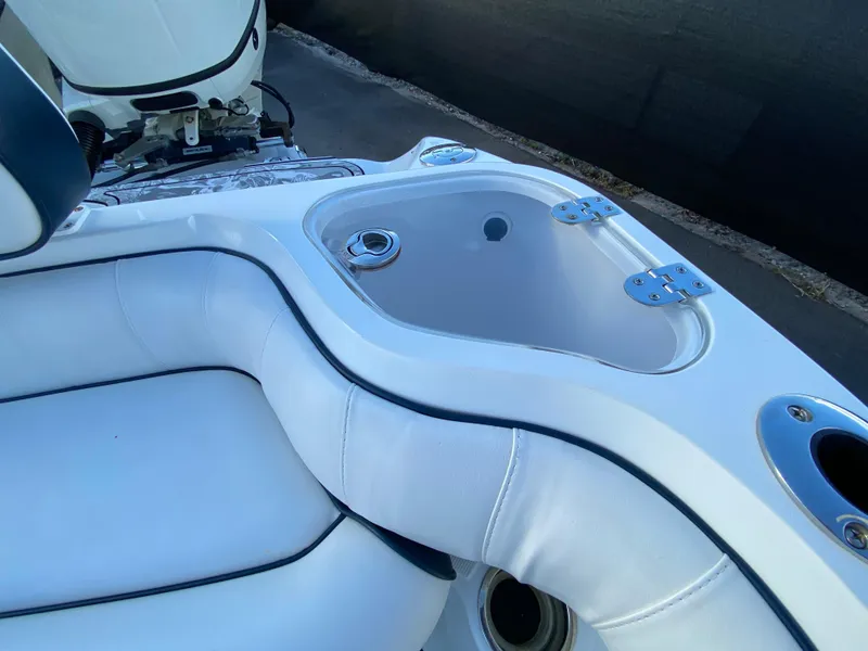 Slide: The Image of 2020 Glasstream 280 Pro-XS boat interior with white cushioned seating and storage compartment. - 49