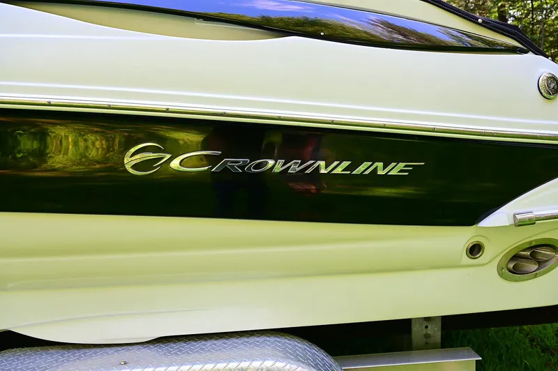 Slide: The Image of 2015 Crownline 236 boat side view with logo and sleek design. - 15