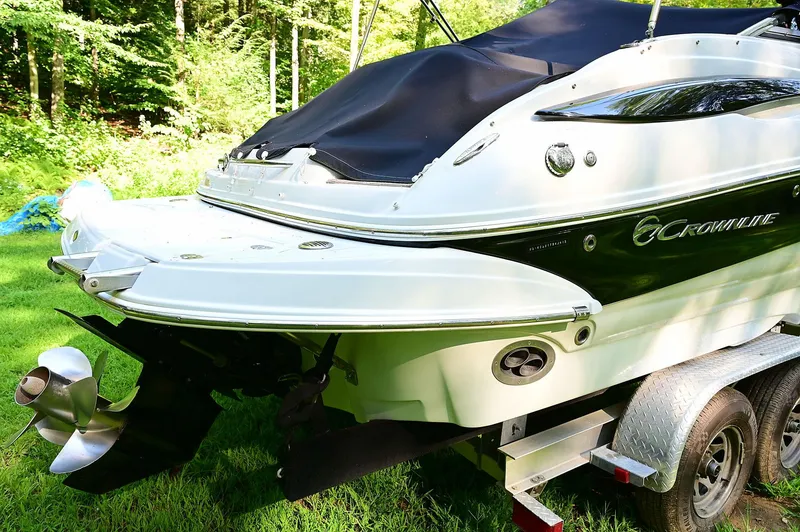 Slide: The Image of 2015 Crownline 236 boat on trailer, rear view, in a grassy area with trees. - 17