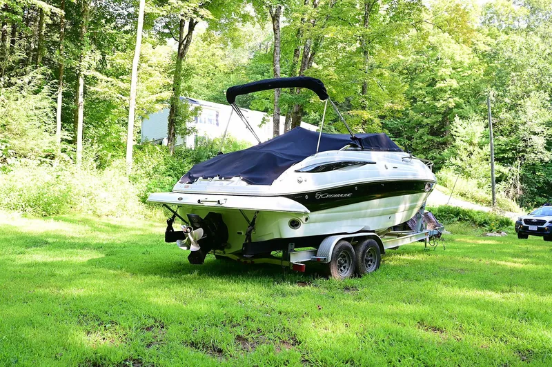 Slide: The Image of 2015 Crownline 236 boat on trailer in lush green yard. - 2