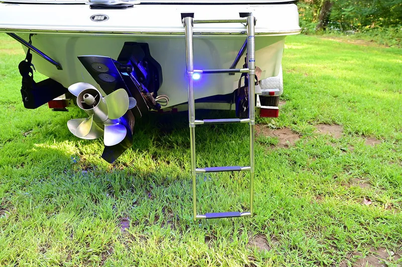 Slide: The Image of 2015 Crownline 236 boat stern with ladder and propeller on grass. - 24