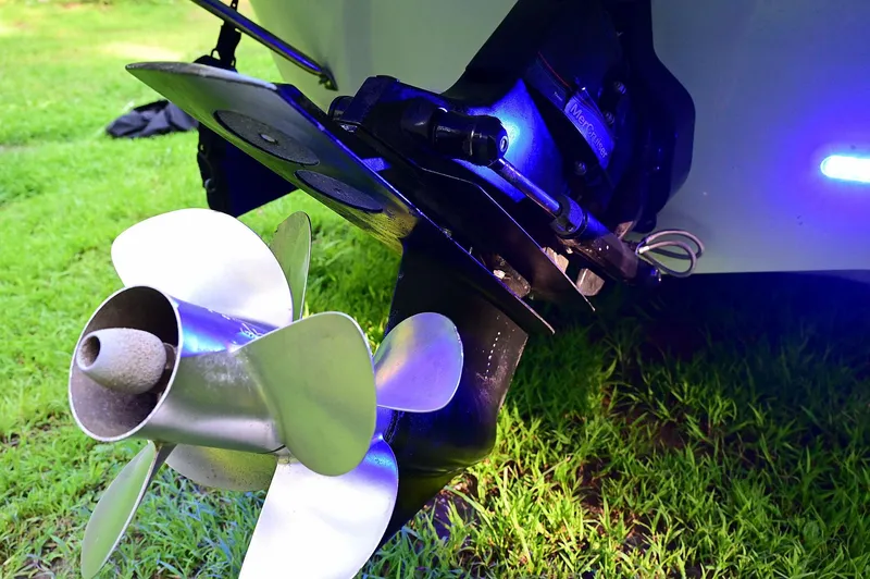 Slide: The Image of Close-up of a 2015 Crownline 236 boat propeller on grass, illuminated by blue light. - 26