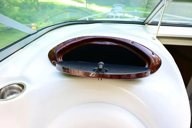 Slide: The Image of 2015 Crownline 236 boat dashboard with open glove compartment. - 36