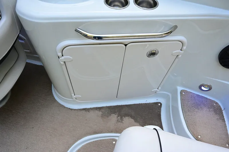 Slide: The Image of 2015 Crownline 236 boat interior with storage compartment and cup holders. - 46