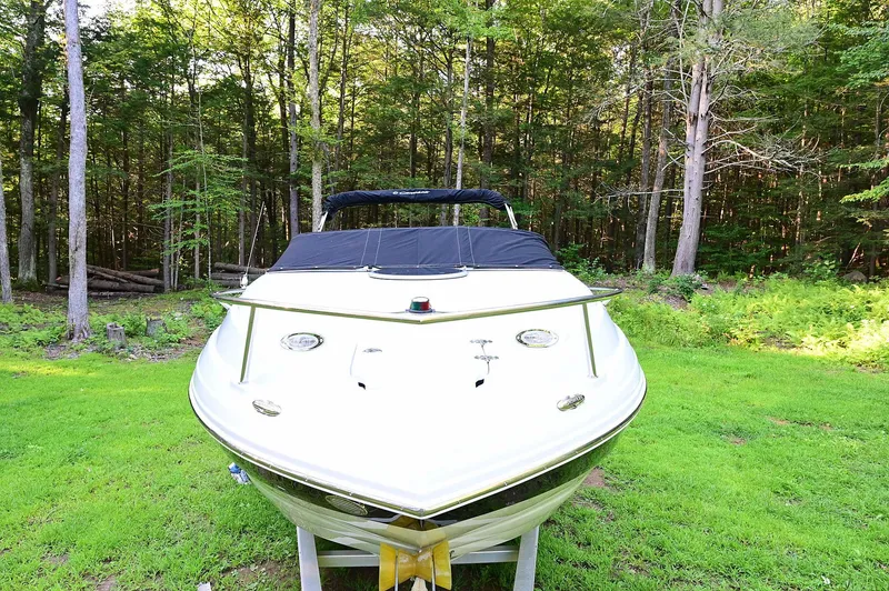 Slide: The Image of 2015 Crownline 236 boat on grass, surrounded by lush forest. - 7