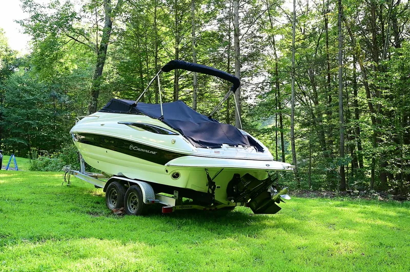 Slide: The Image of 2015 Crownline 236 boat on trailer in lush green forest setting. - 9