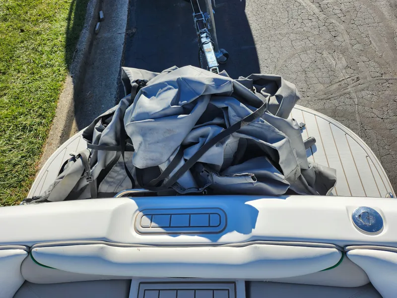 Slide: The Image of 2007 Tigé 22i boat with cover on deck, parked on street. - 22