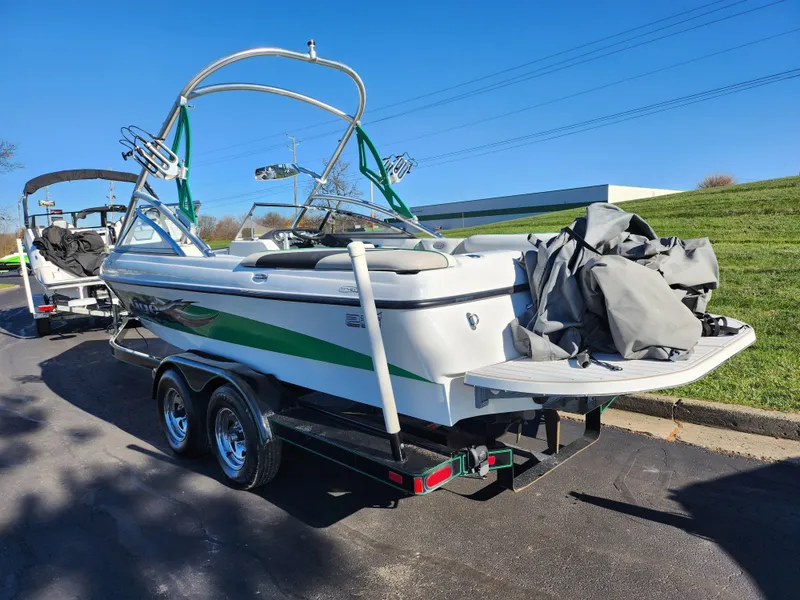 Slide: The Image of 2007 Tigé 22i boat on trailer, parked outdoors under clear blue sky. - 4