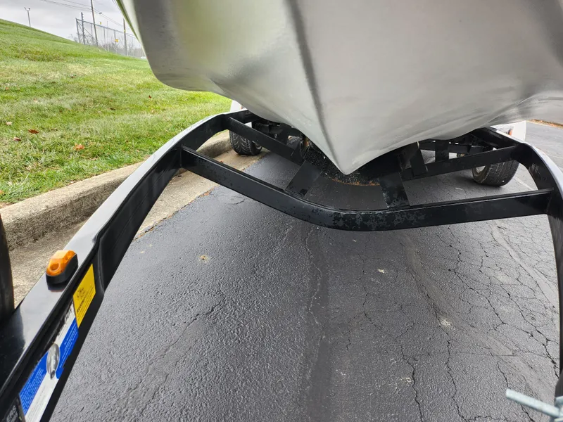 Slide: The Image of 2004 Supra Launch SSV boat on trailer, parked on asphalt near grass. - 7