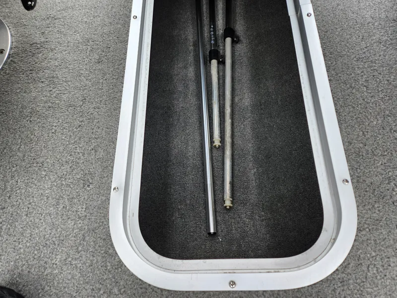Slide: The Image of Storage compartment in 2004 Chaparral 180 SSi boat with metal poles inside. - 13