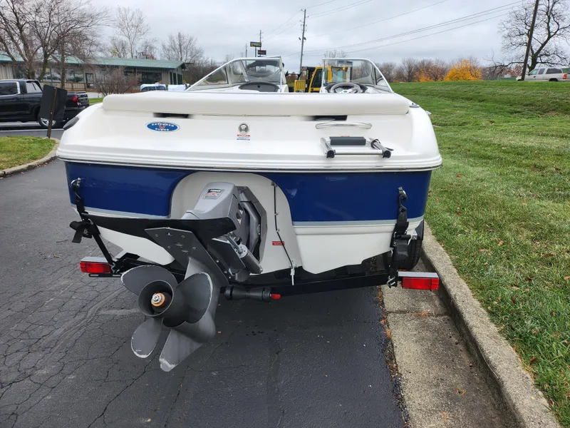 Slide: The Image of 2004 Chaparral 180 SSi boat, rear view, parked on pavement near grass. - 2