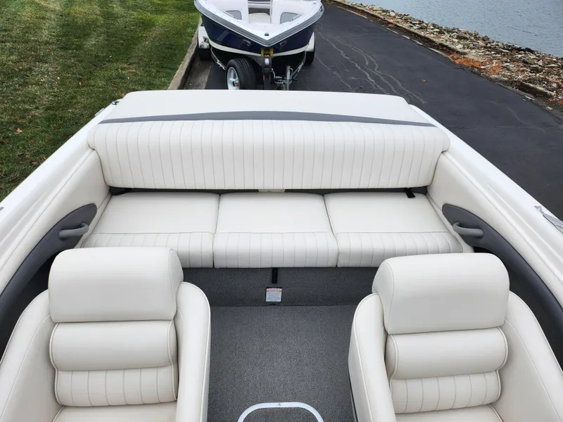 Slide: The Image of 2004 Chaparral 180 SSi boat interior with white leather seats and trailer in background. - 20