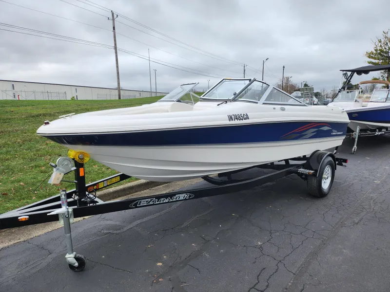 Slide: The Image of 2004 Chaparral 180 SSi boat on trailer, white with blue accents, parked on asphalt. - 5