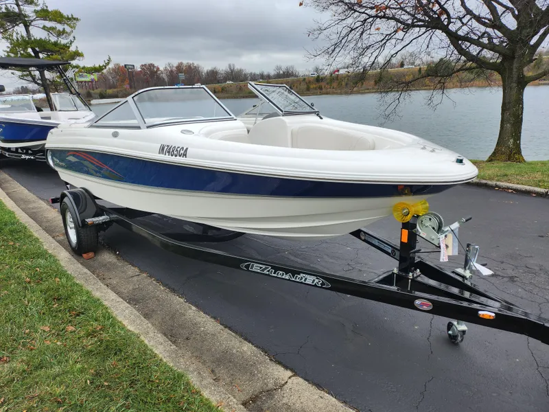 Slide: The Image of 2004 Chaparral 180 SSi boat on trailer by a lakeside road. - 9