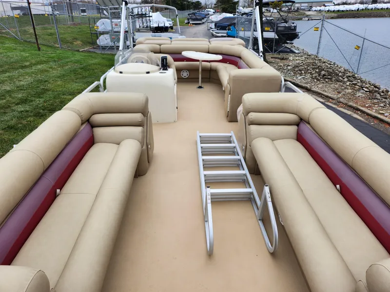 Slide: The Image of 2000 Bennington 2580LX pontoon boat with beige and red seating, docked near a lake. - 10
