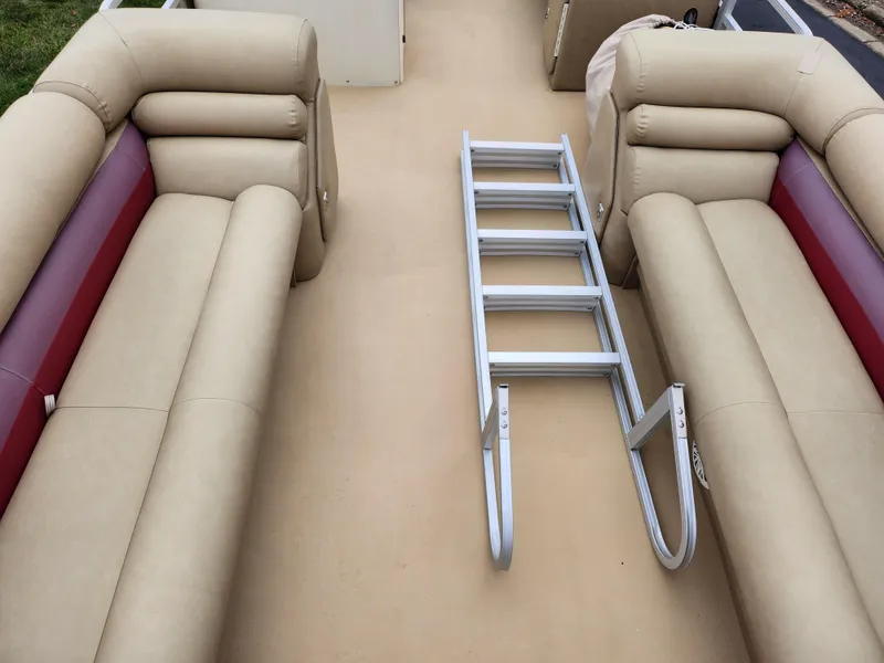 Slide: The Image of Bennington 2580LX 2000 boat interior with beige seating and metal ladder. - 11