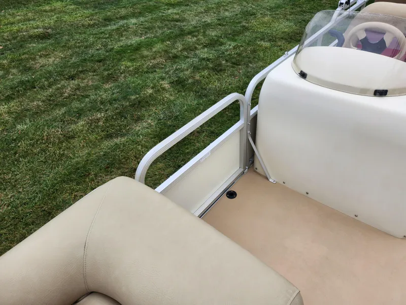 Slide: The Image of Bennington 2580LX pontoon boat interior, beige seating, grassy background, 2000 model. - 13