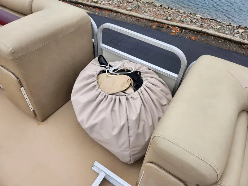 Slide: The Image of Bennington 2580LX boat interior with covered equipment, near water, 2000 model. - 14