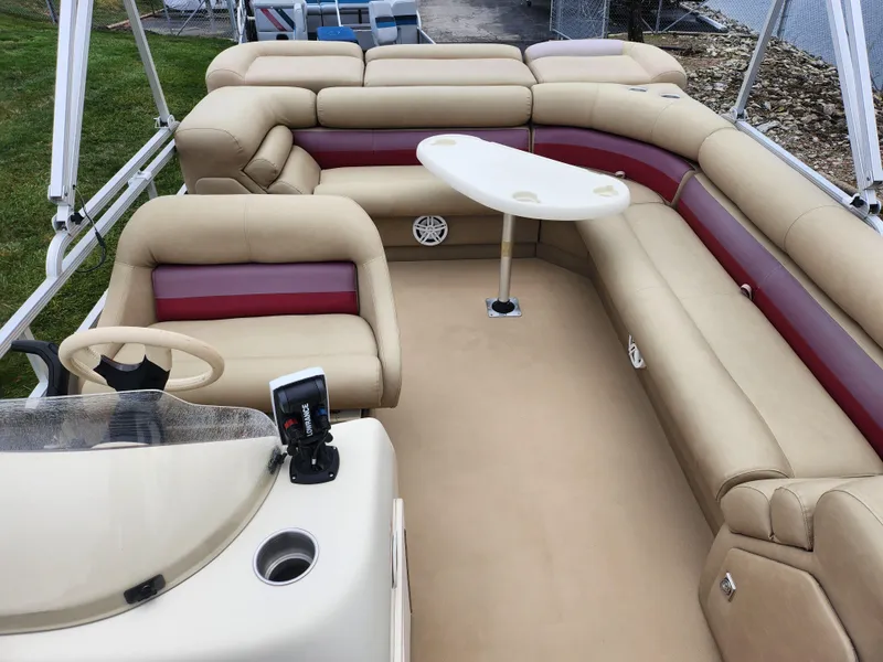 Slide: The Image of Bennington 2580LX 2000 pontoon boat interior with beige and red seating, small table. - 15