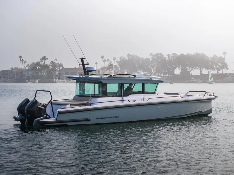 Slide: The Image of 2023 Axopar 37 Aft Cabin boat on calm water, misty background. - 12