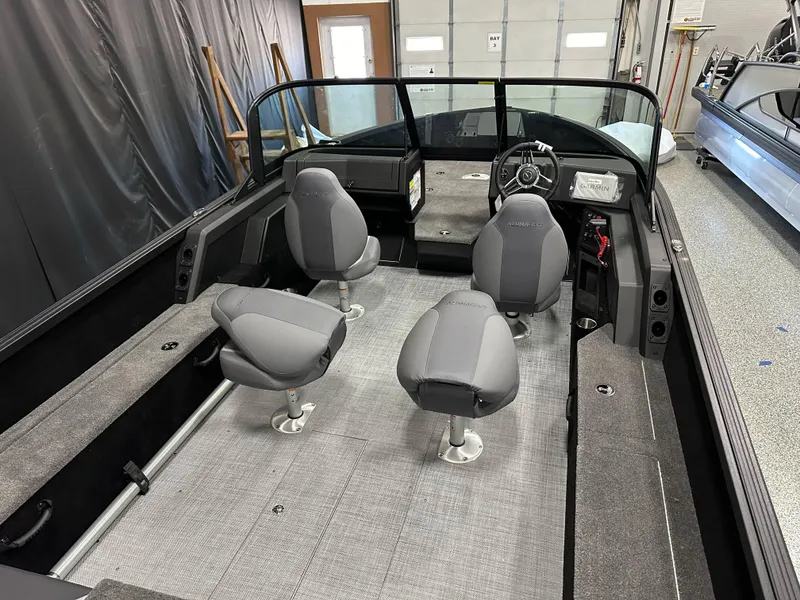 Slide: The Image of 2025 Alumacraft Competitor 205X Sport interior with gray seating and modern dashboard. - 19