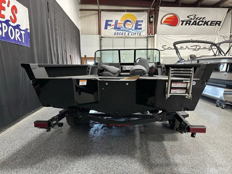 Slide: The Image of 2025 Alumacraft Competitor 205X Sport boat in showroom, rear view with ladder and seats. - 22