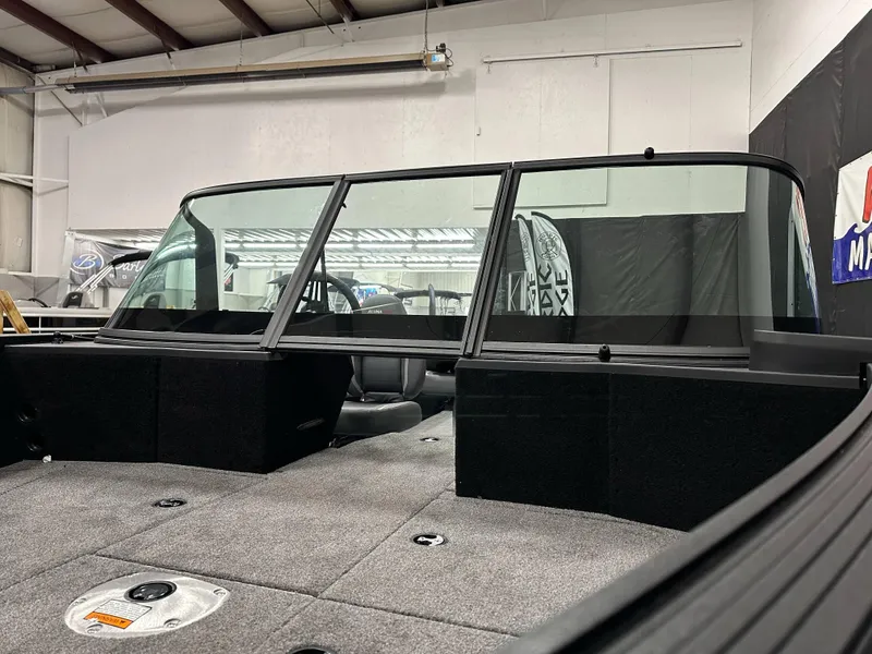 Slide: The Image of 2025 Alumacraft Competitor 205X Sport boat interior with windshield and carpeted deck. - 5