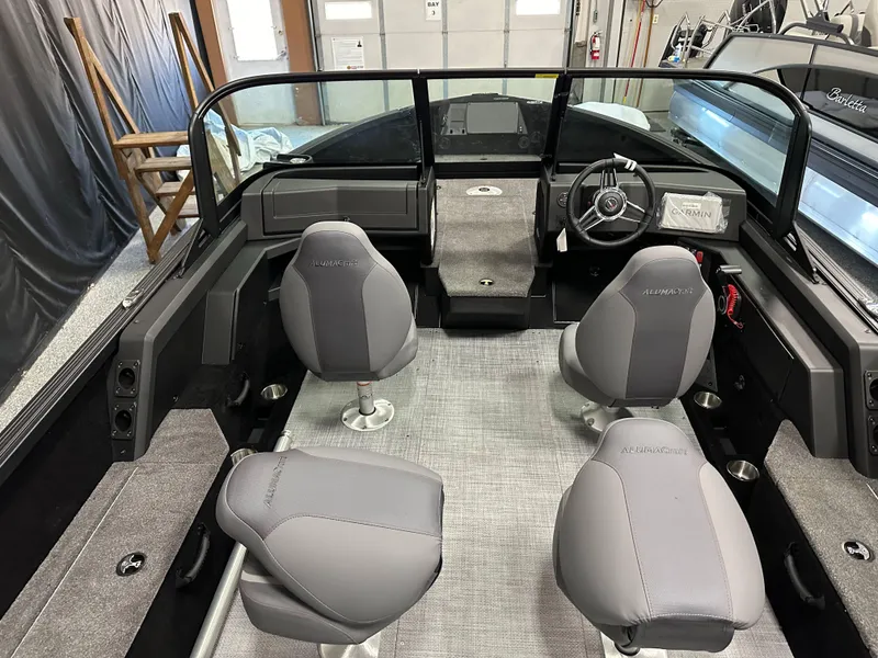 Slide: The Image of 2025 Alumacraft Competitor 205X Sport interior with gray seating and modern dashboard. - 7