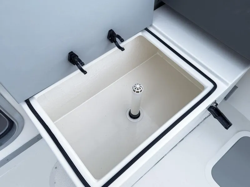 Slide: The Image of Defiance 260 Admiral 2025 boat storage compartment with open lid and drainage system. - 10