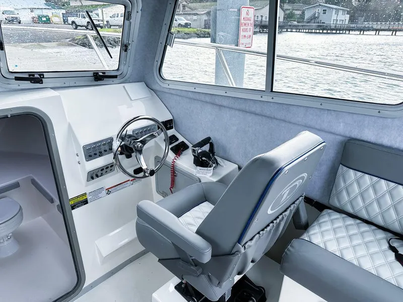 Slide: The Image of Interior of 2025 Defiance 260 Admiral boat with steering wheel and seating. - 6