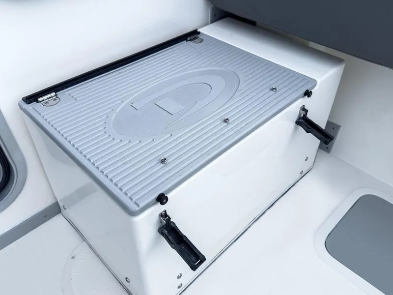 Slide: The Image of Defiance 260 Admiral 2025 boat storage compartment with secure latches and ribbed lid design. - 9